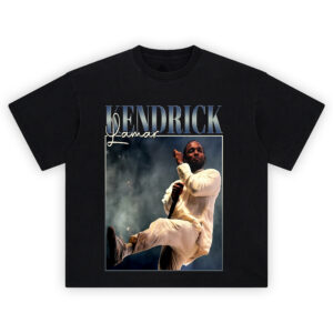 Kendrick Lamar Live Performance T-Shirt with Kendrick mid-kick in cream suit on stage, smoky background, metallic name text above.