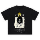J Cole 1985 T-Shirt featuring grayscale portrait of Cole, handwritten 1985 text, signature, and yellow crown over clean line design.