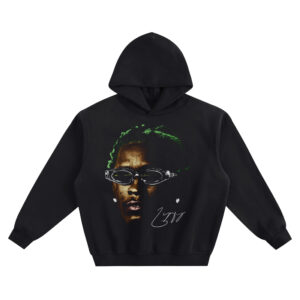 Young Thug Big Face Hoodie graphic showing a close-up portrait of Young Thug with green hair, clear oval goggles, small white star accents, and a signature-style mark on a black hoodie.