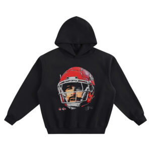 Travis Kelce Big Face Hoodie graphic showing a close-up portrait of Travis Kelce in a red Kansas City Chiefs helmet with signature detail on a black hoodie.