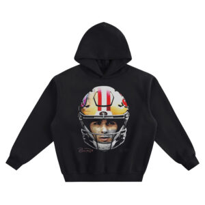 Brock Purdy Big Face Hoodie graphic showing a head-on close-up portrait of Brock Purdy in a gold San Francisco 49ers helmet with red center stripe and small “B.P.” signature on a black hoodie.