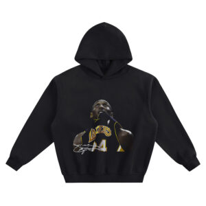 Kobe Bryant Big Face Hoodie graphic showing a close-up portrait of Kobe Bryant in a Lakers “LAKERS” #24 jersey with jersey-bite pose and a white signature-style mark on a black hoodie.