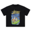 The Jetsons Graphic Tee graphic showing large yellow “THE Jetsons” script above a blue futuristic city scene with the family riding in a green flying car under a clear dome on a black tee.